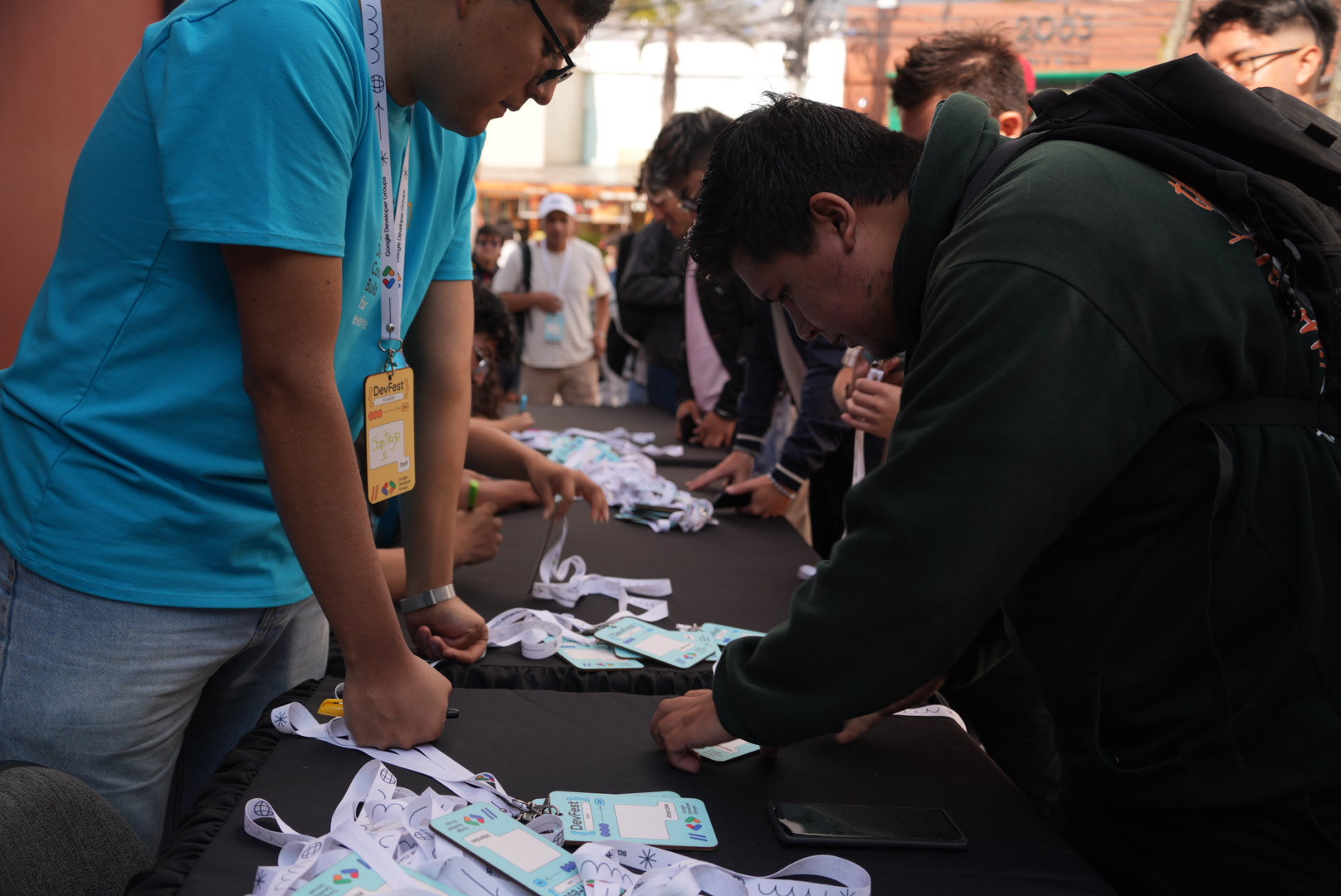 Equipo de registro entregando credenciales en el check-in de DevFest Quito