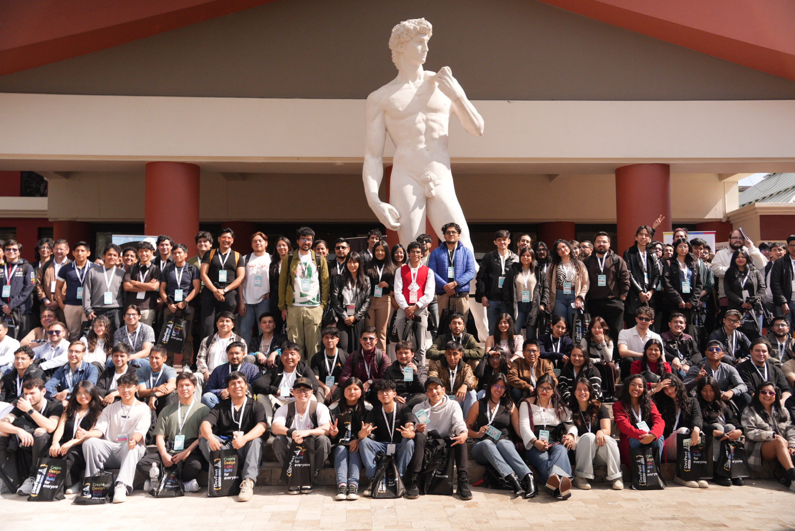Asistentes de DevFest Quito en foto grupal frente al campus USFQ